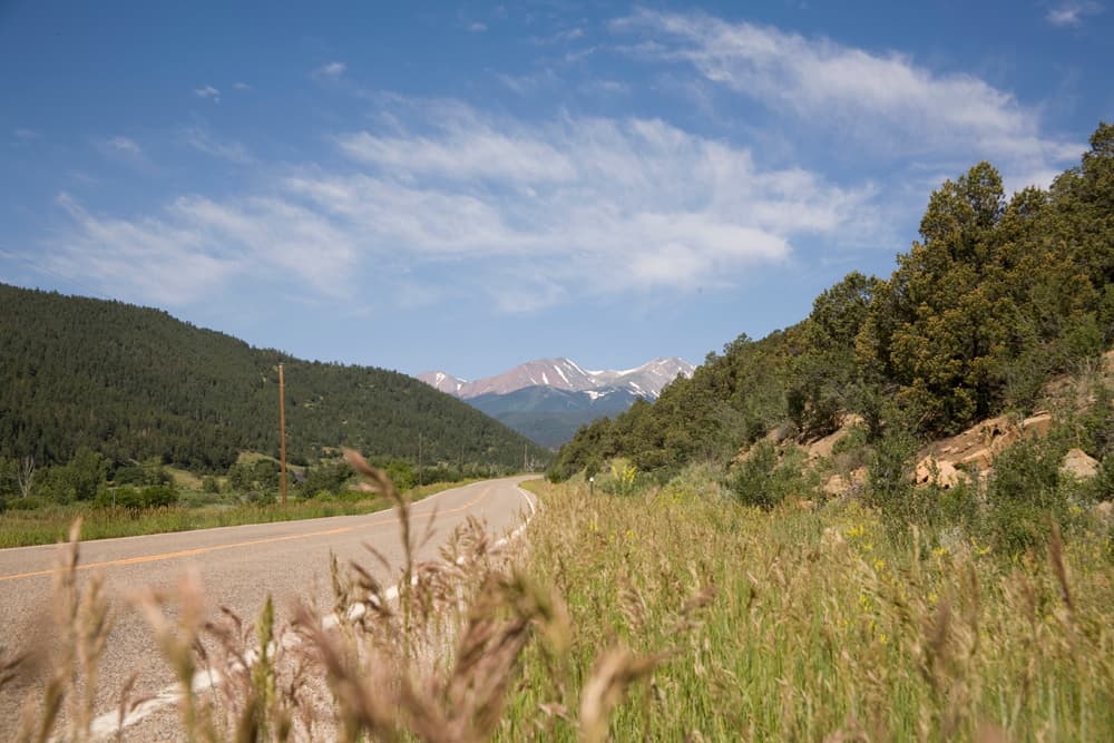 A long road winds through the valley with mountains on both sides