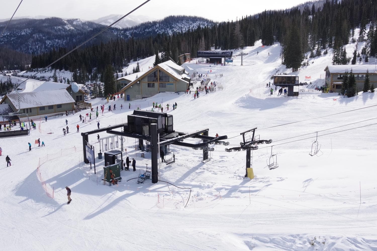 view of wolf creek's base area; specifically the bonanza lift with the nova and treasure lifts in the background as well as the main day lodge, wolf creek lodge. photo