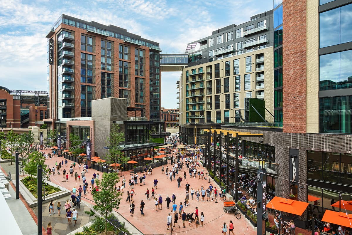 People explore the plaza and outdoor dining areas near The Rally Hotel in Denver, Colorado.