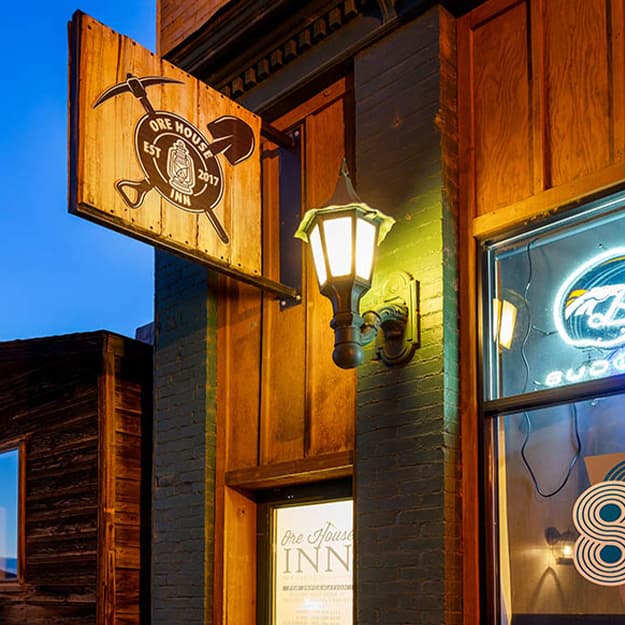 In New Castle, Colorado, a wooden sign hangs over a door by a local shop and is emblazoned with the words, "Ore House Inn."