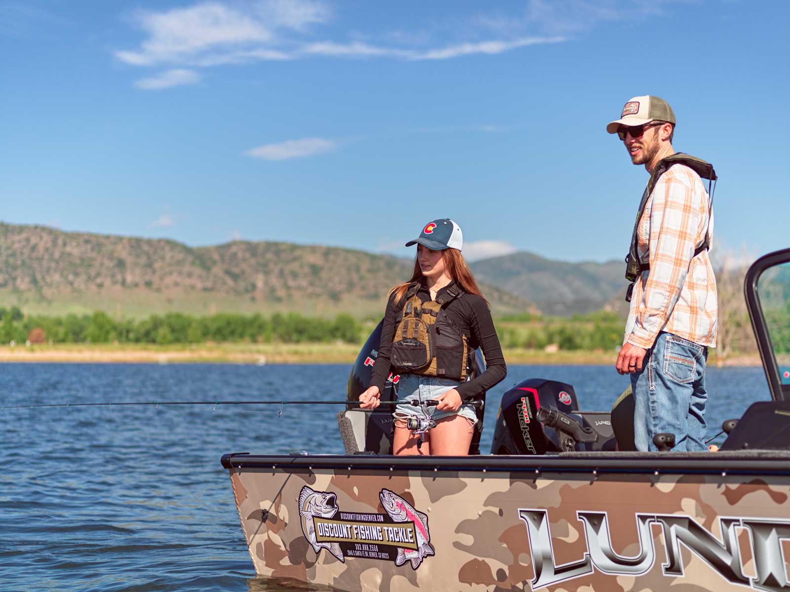 Two people fish from a boat