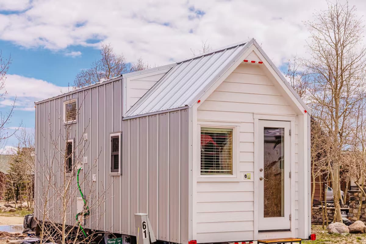 Featuring white, wooden siding, the Tumbleweed Tiny Home is a welcome retreat for guests in Fairplay, Colorado.