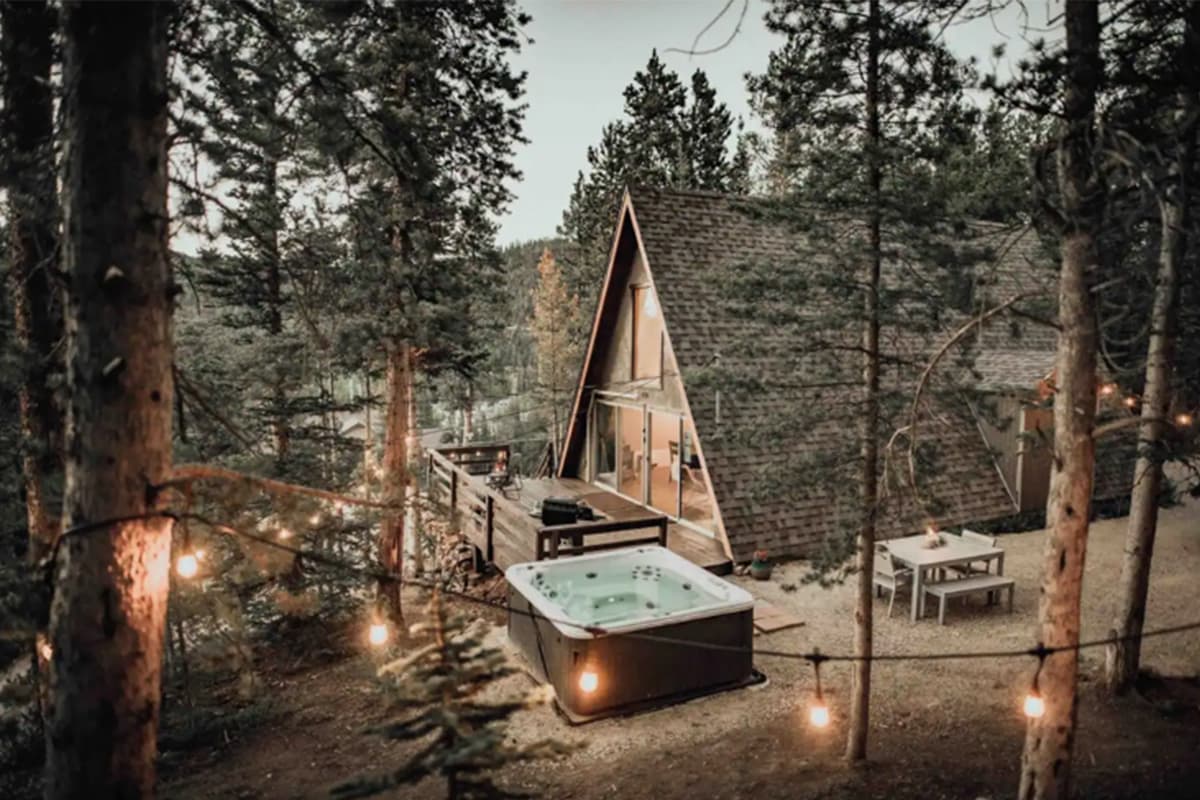 High Point Hideaway is a cozy A-frame cottage nestled amid tall pine trees near Breckenridge, Colorado.