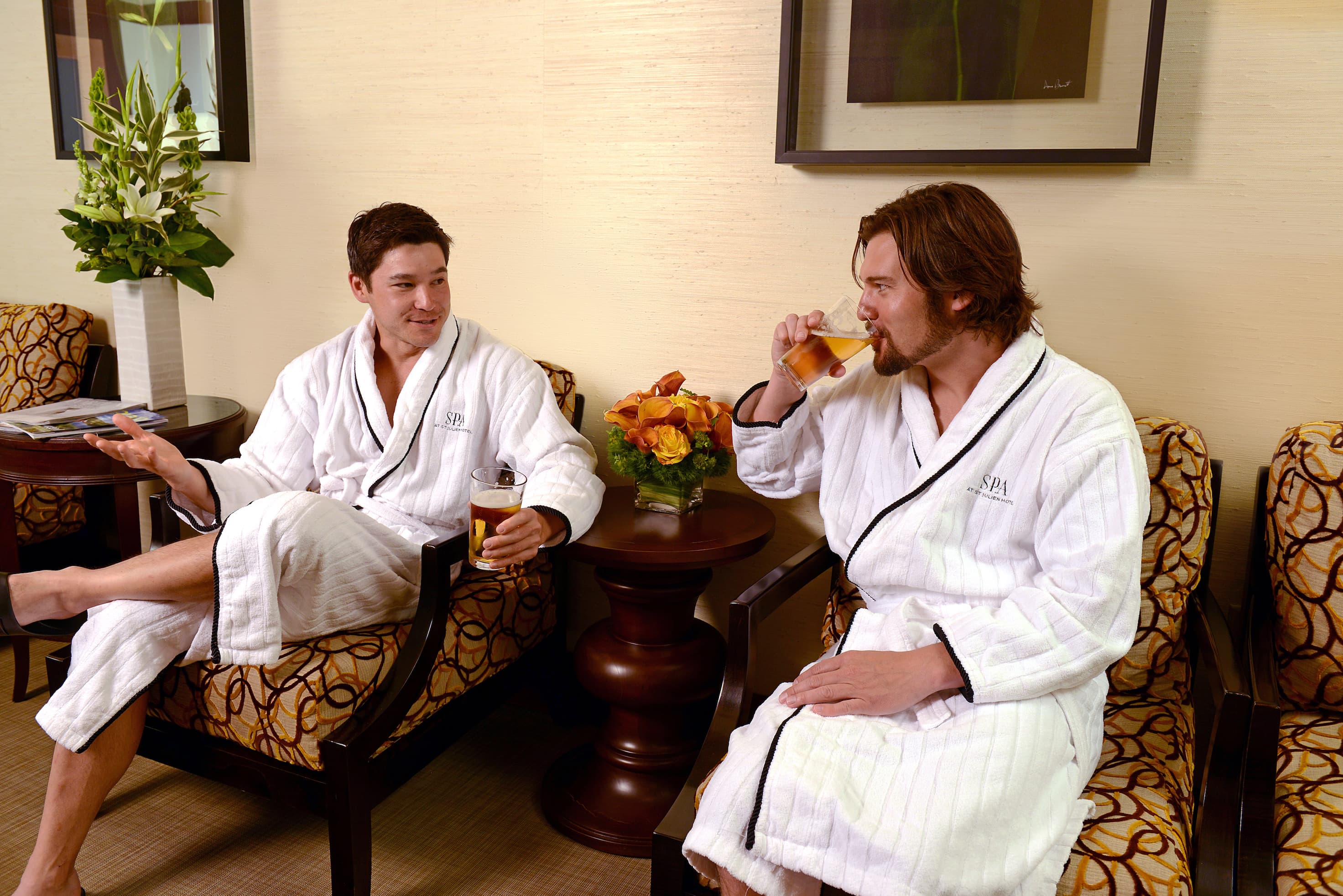 Two men sip beverages while wearing robes at the spa in Boulder's St. Julien Hotel & Spa.
