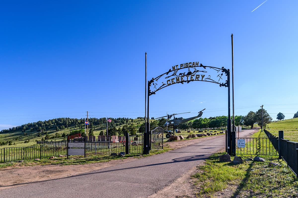 Gate and sign that reads Mt. Pisgah Cemetery, with tombstones behind it