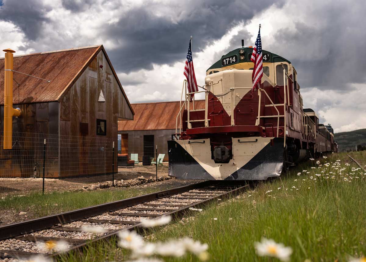 Exterior of S.L.umber Yard at FREIGHT with train on tracks nearby