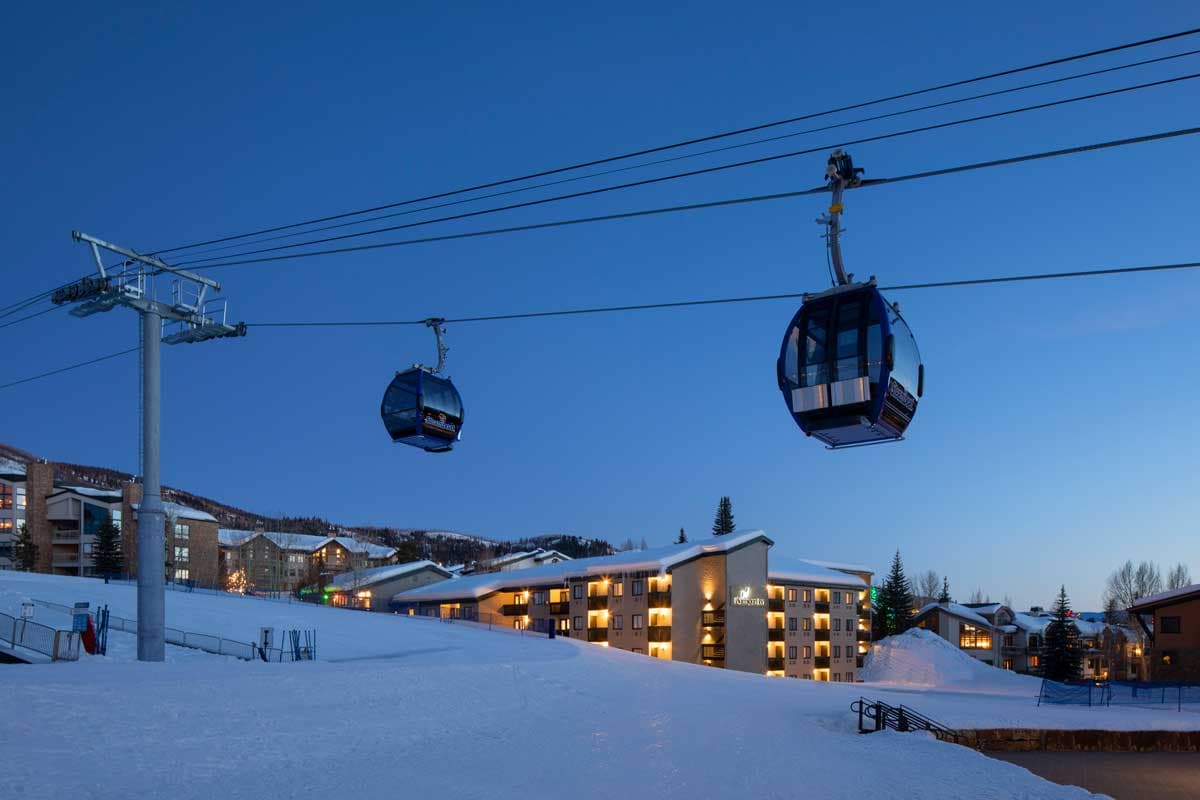 Ski gondolas at Gravity Haus Steamboat. It is early morning and the light is brightening on the horizon.