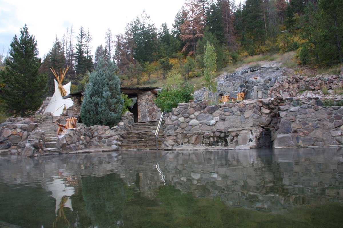 Strawberry Park Hot Springs pool ringed by leafy trees and rocks