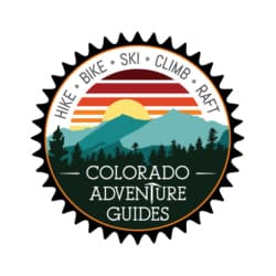 Colorado Adventure Guides logo shaped like a bike cog inside of which is an illustration of evergreen trees in front of a illustrated mountain sunset with the text "hike" "bike" "ski" "climb" "raft"arching over the sunset. 