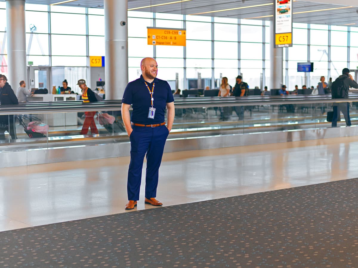 A man in a lanyard stands at Denver International Airport
