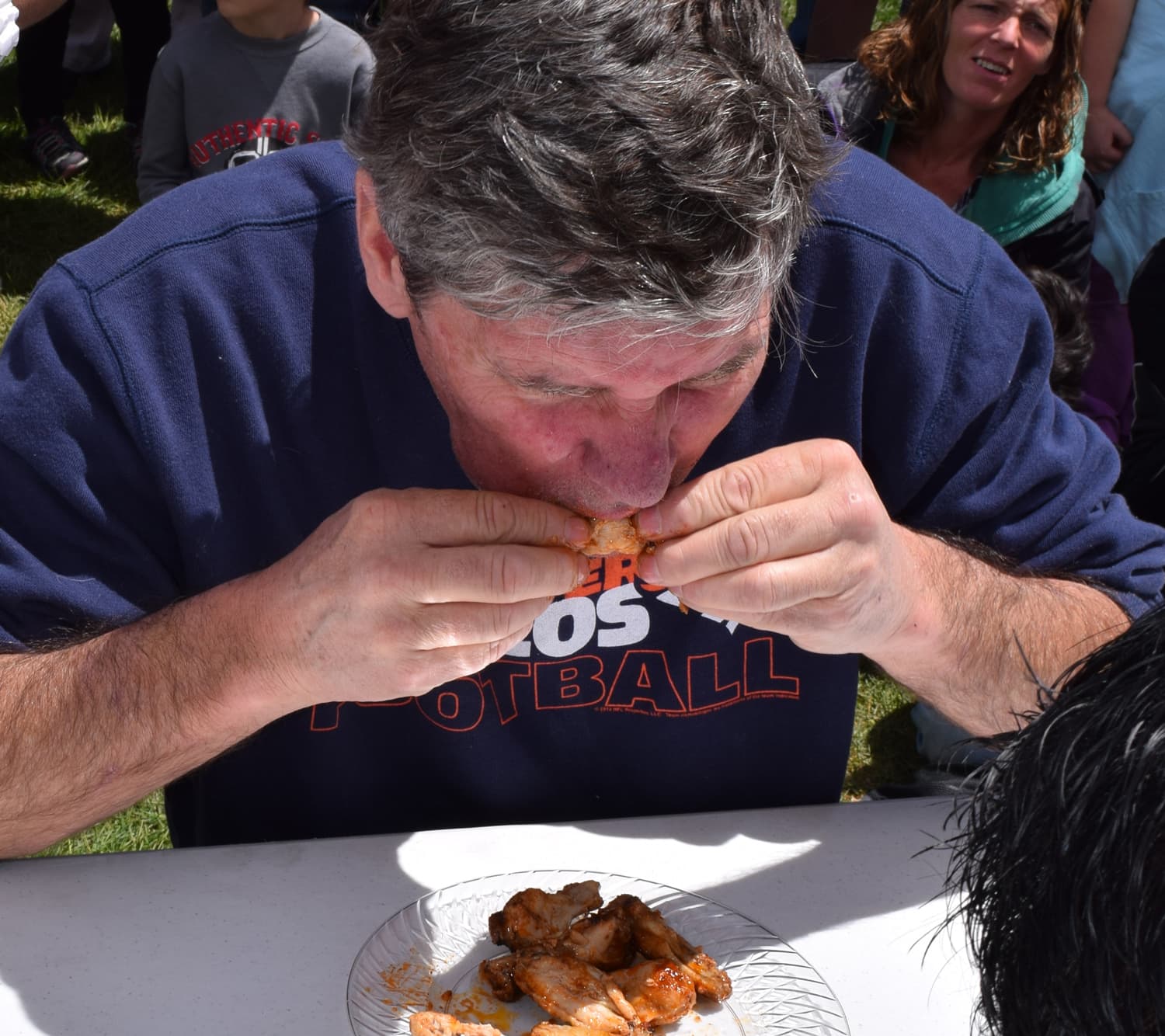 Man eats a wing during wing-eating contest at Mike the Headless Chicken Festival 