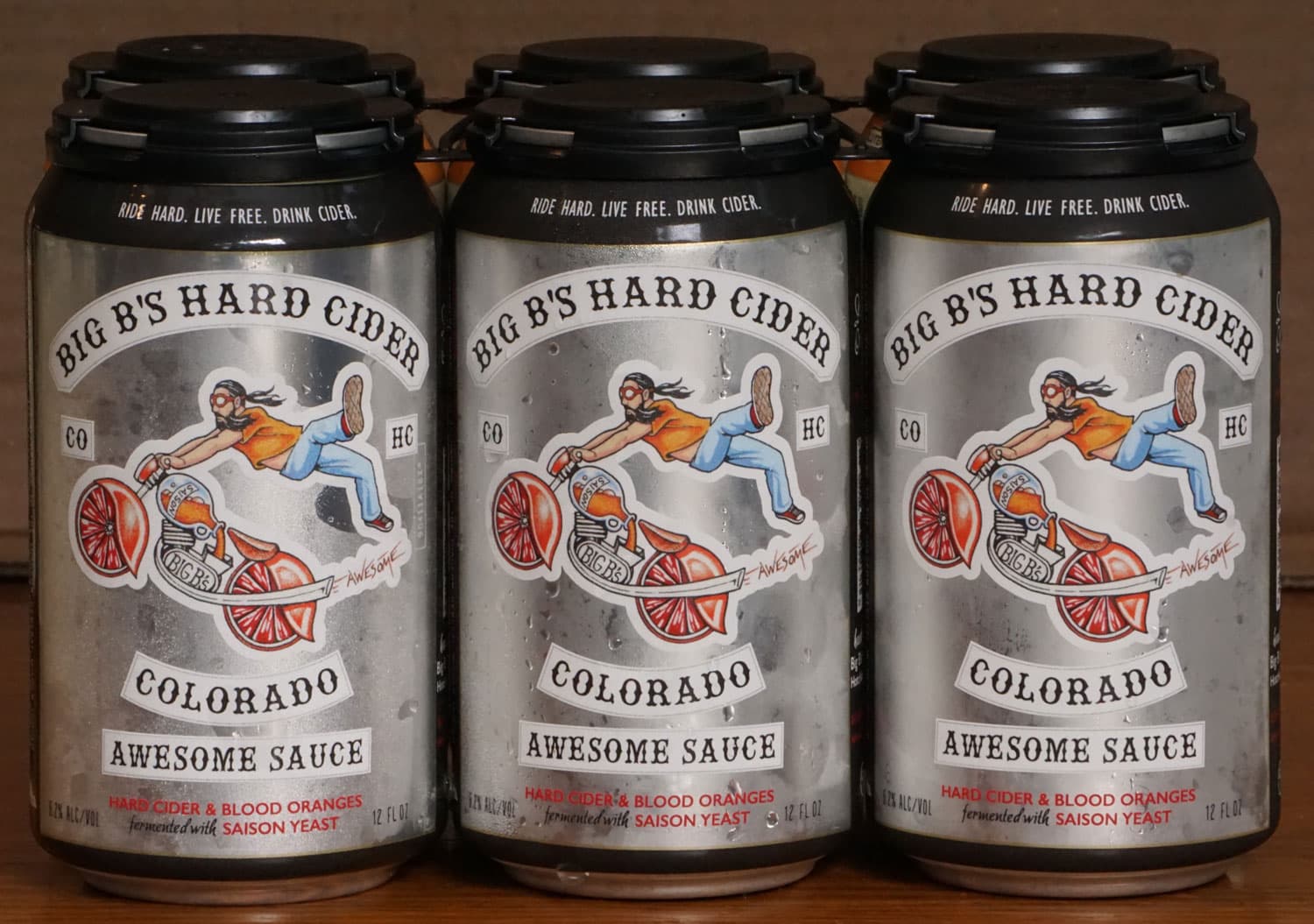 A design on a can of Big B's Hard Cider, Hotchkiss, features a person flying off a cider and fruit-style motorcycle.