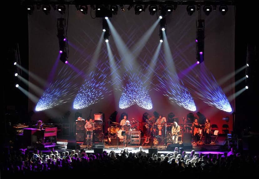 A nighttime concert with a band and strobe lights. 