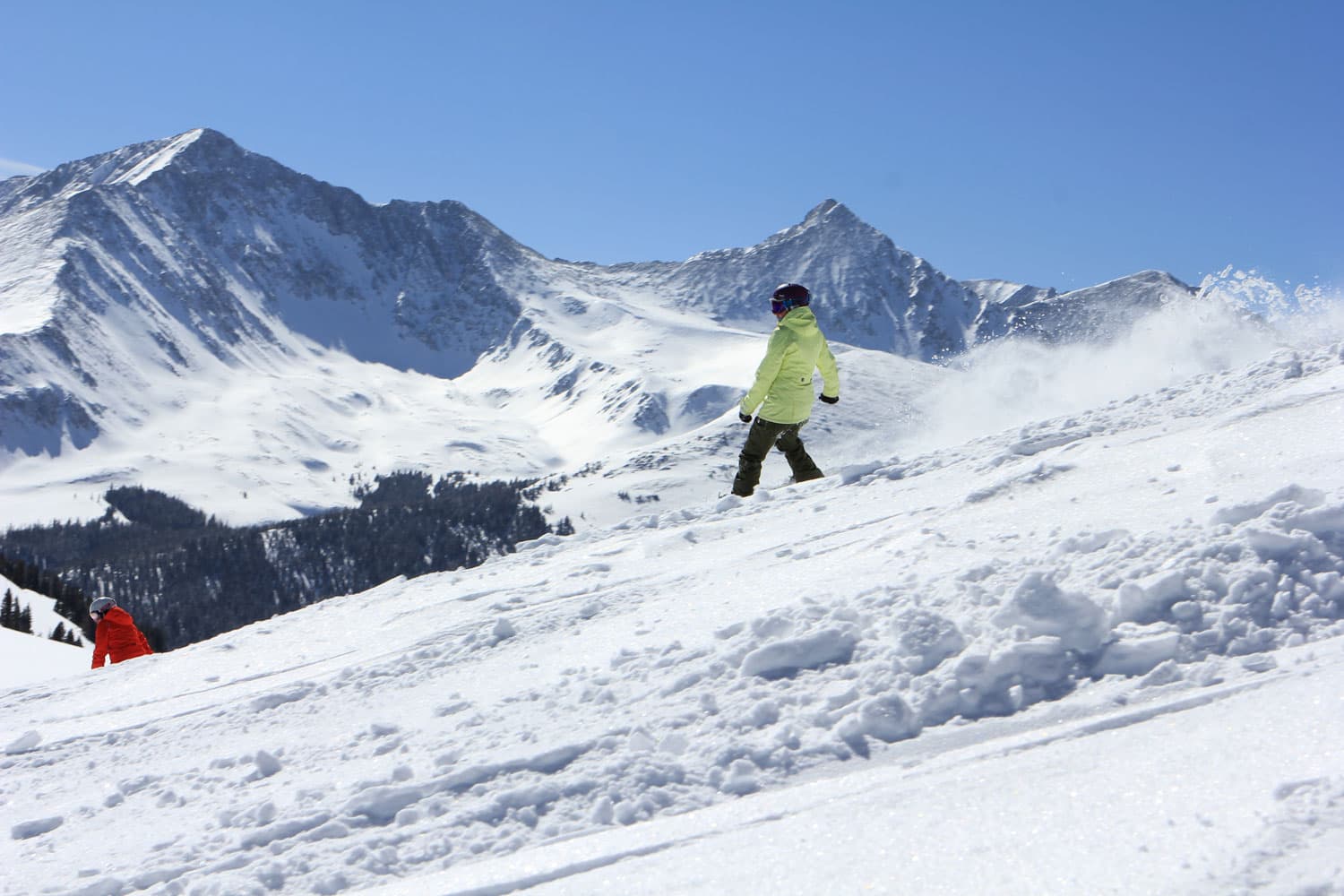 Snowboarder gliding down steep, snow-covered slopes at Copper Mountain, Colorado.