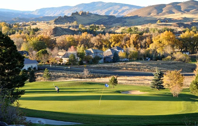 As the setting sun starts to cast its shadow, we see the empty golf course in the foreground. Beyond, rolling foothills and groves of trees with fall's changing colors provide a deep panorama