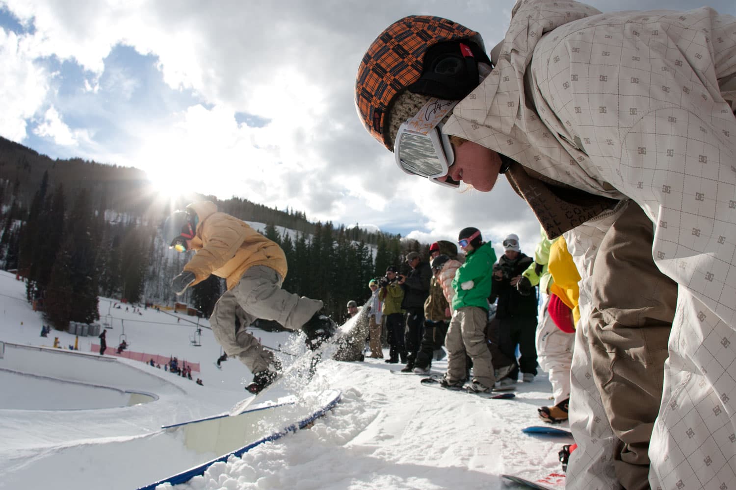 A lineup of geared snowboarders preparing for a descent at Vail Mountain, Colorado.