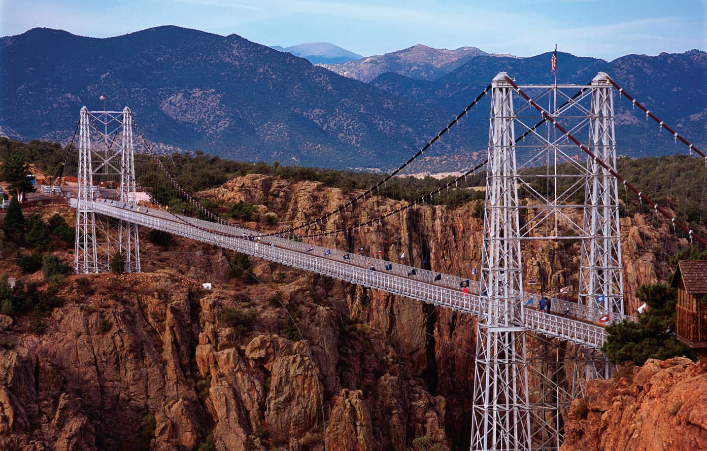 The Royal Gorge Bridge , a metal suspension bridge, allows travelers to trek across the gaping expanse of the rocky gorge in Colorado.