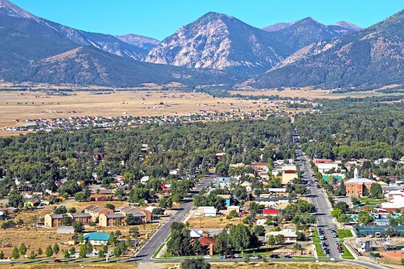 An aerial shot of Buena Vista in the summer with the tall Collegiate Peaks in the background under a bright-blue sky.