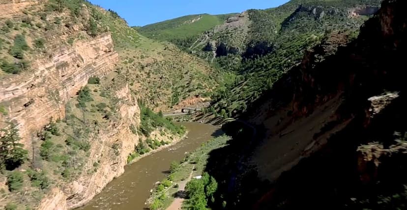 The brownish waters of the Colorado River flow through a canyon