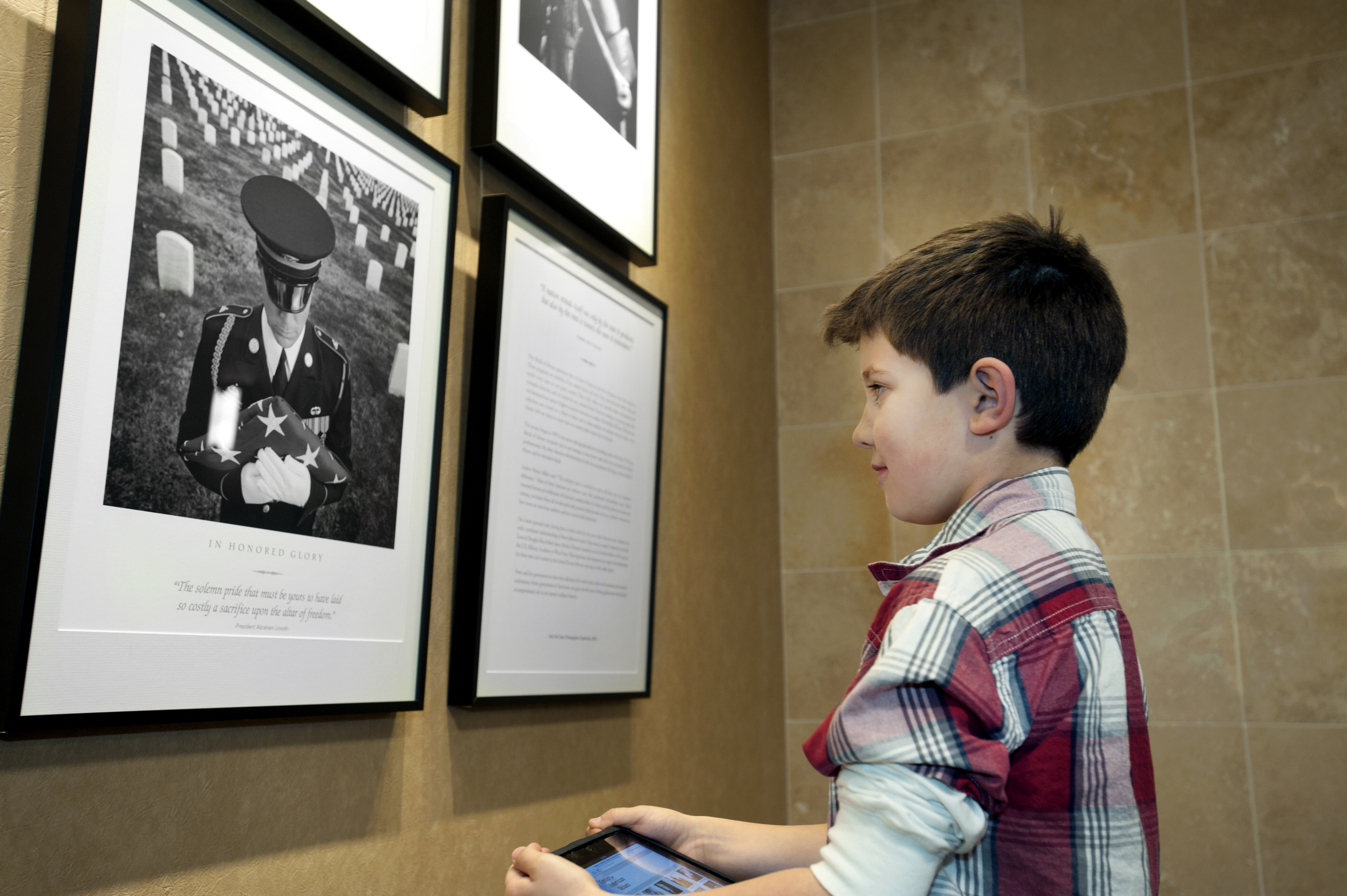 a young man learns about americas heroes while in the portraits of valor gallery photo