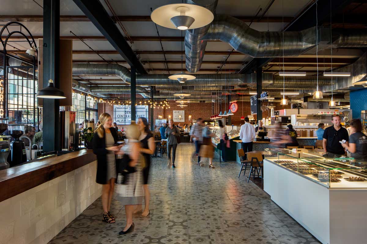 Groups of peaple gathered by different food booths in a food hall