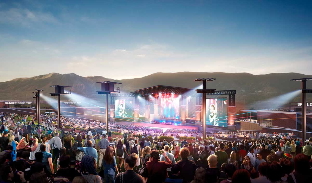 A crowd looks upon the stage and lights of an outdoor amphitheater