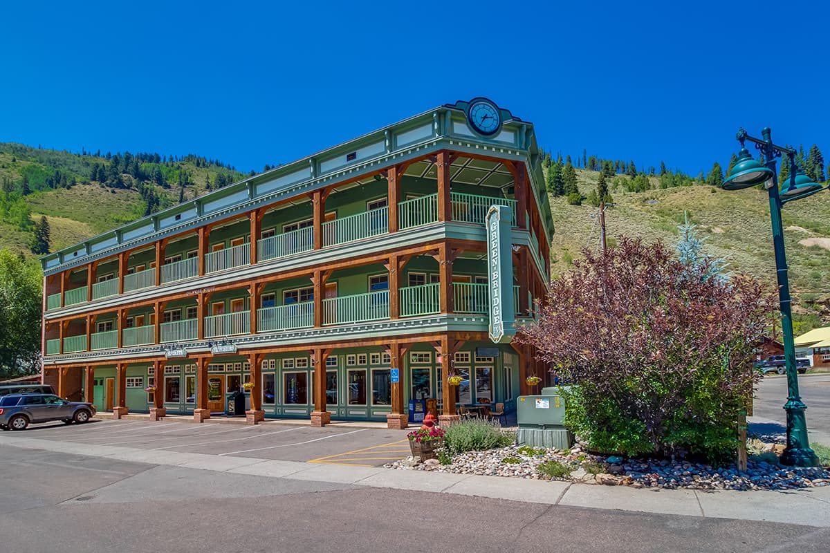 Green Bridge Inn stands proud on a corner in Red Cliff, Colorado. The inn is green, wraparound balconies on every floor.