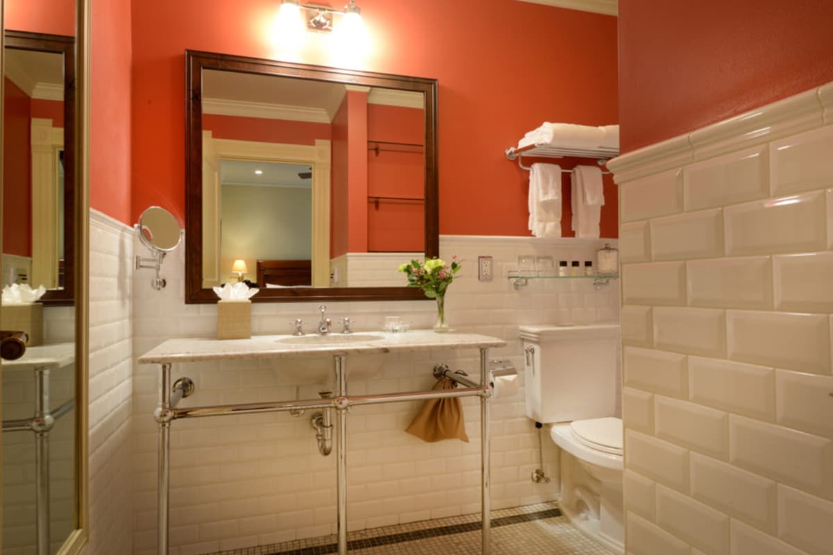 A white tiled and salmon-painted bathroom at the New Sheridan Hotel in Telluride, Colorado, awaits the next round of guests.