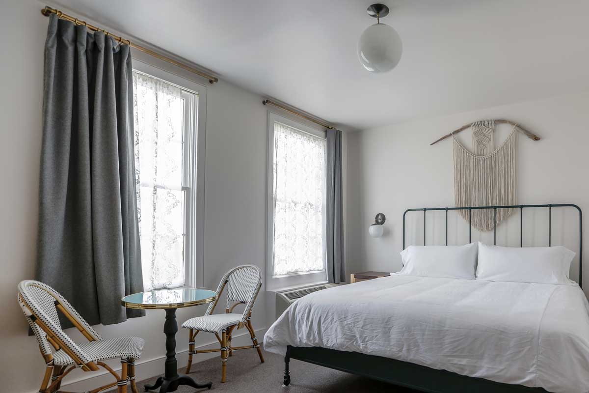 A room at the Surf Hotel in Buena Vista. The room is decorated in light colors with a piece of fiber art above the bed.