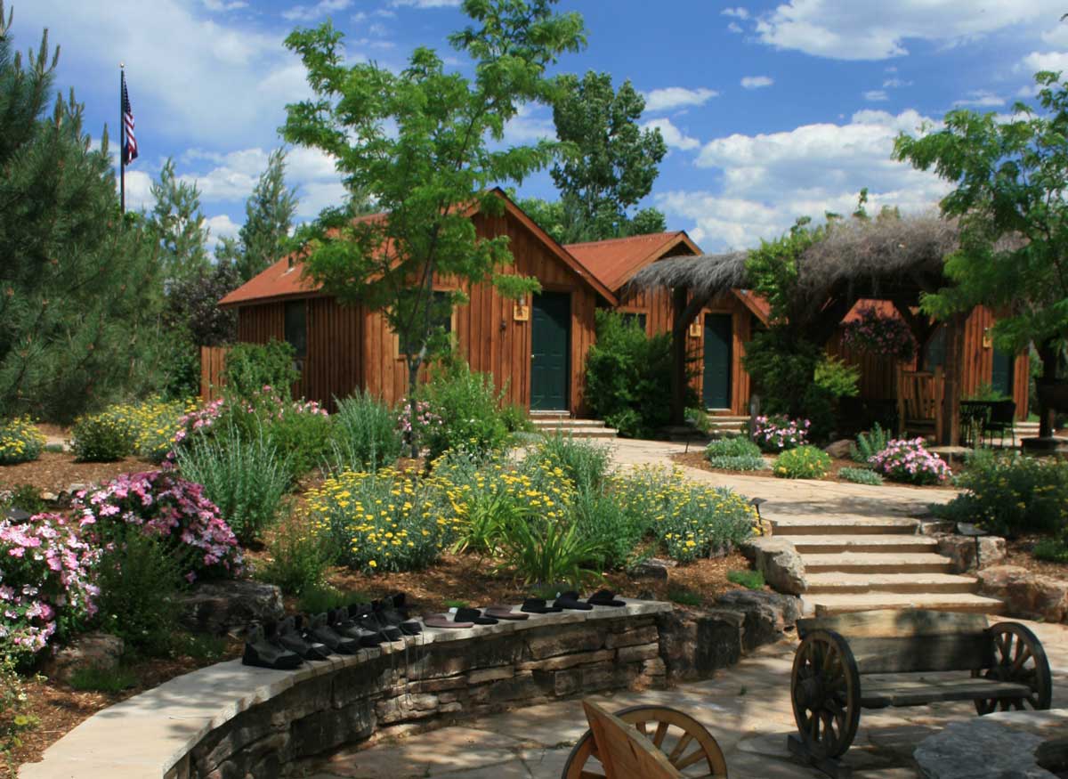 Exterior of Gunnison River Farms with blooming flowers and green, leafy trees.