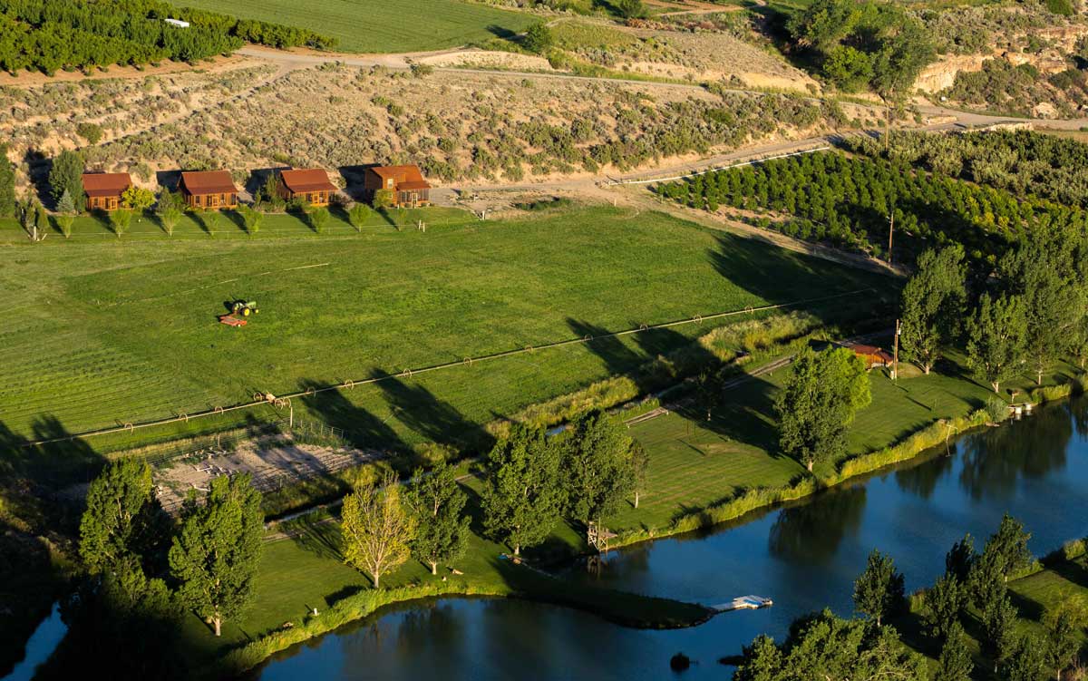 Four Gunnison River Farms cabins seen from bird's-eye view along the Gunnison River