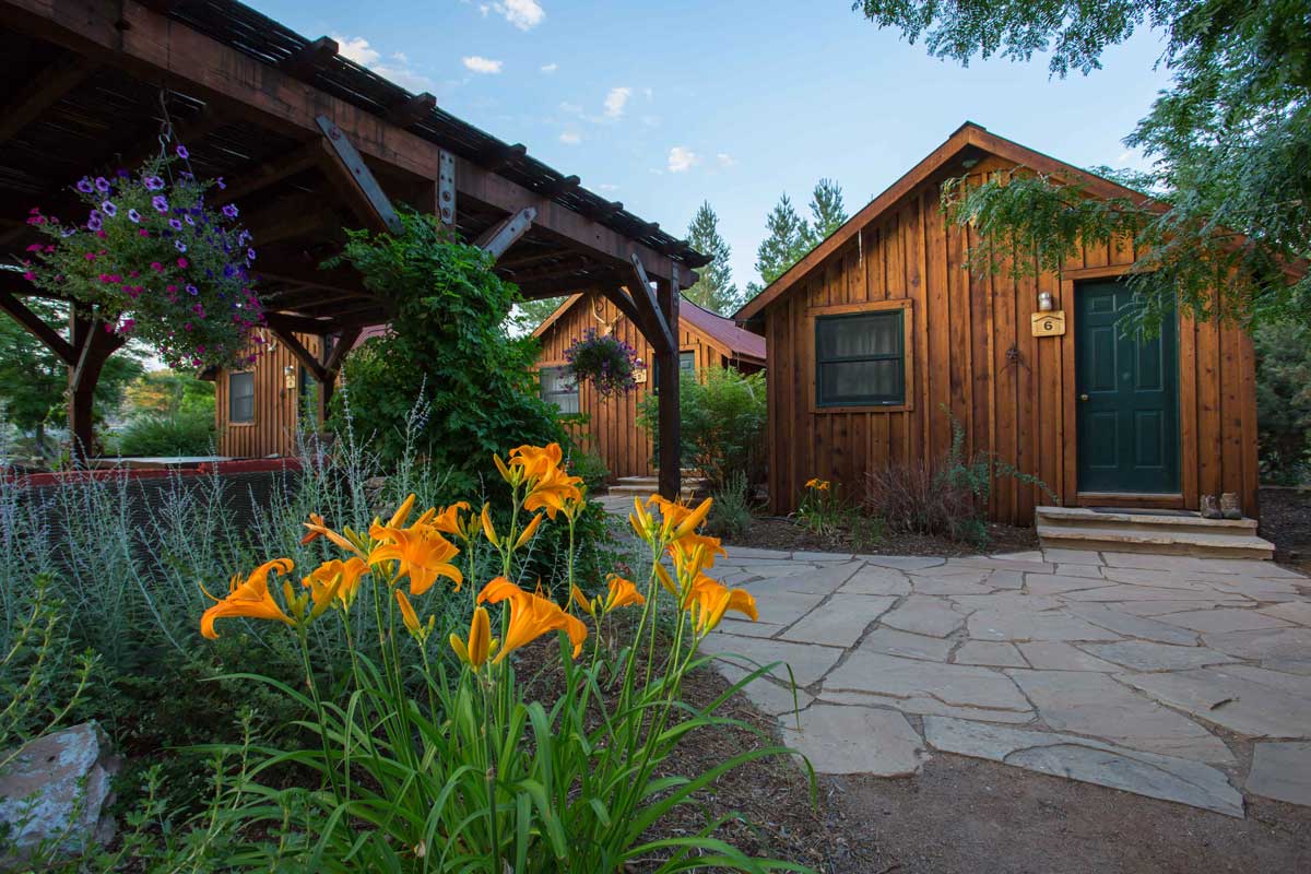 Gunnison River Farms lodgings seen from the exterior with orange lilies in foreground