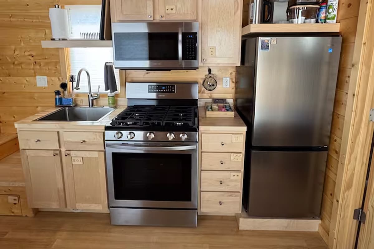 A tiny house in Montrose, Colorado, is filled with bright light, light-wood paneling and a full kitchen.