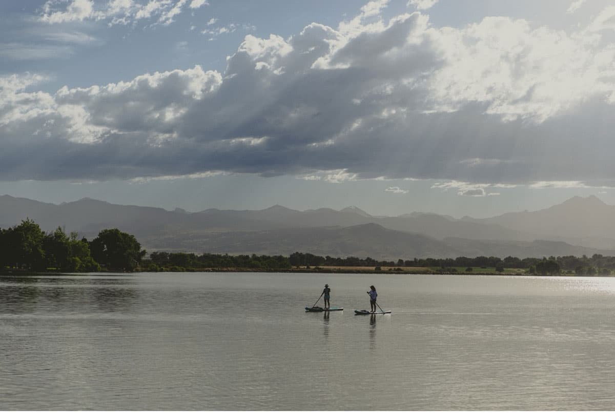 Stand-up paddleboarding on McIntosh Lake under a cloudy sky.