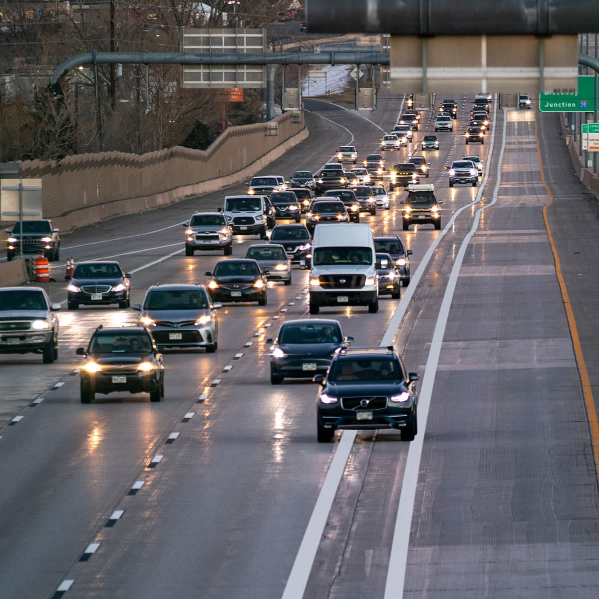 Cars on the road and a black vehicle crossing solid lines, violating the express lane rules.