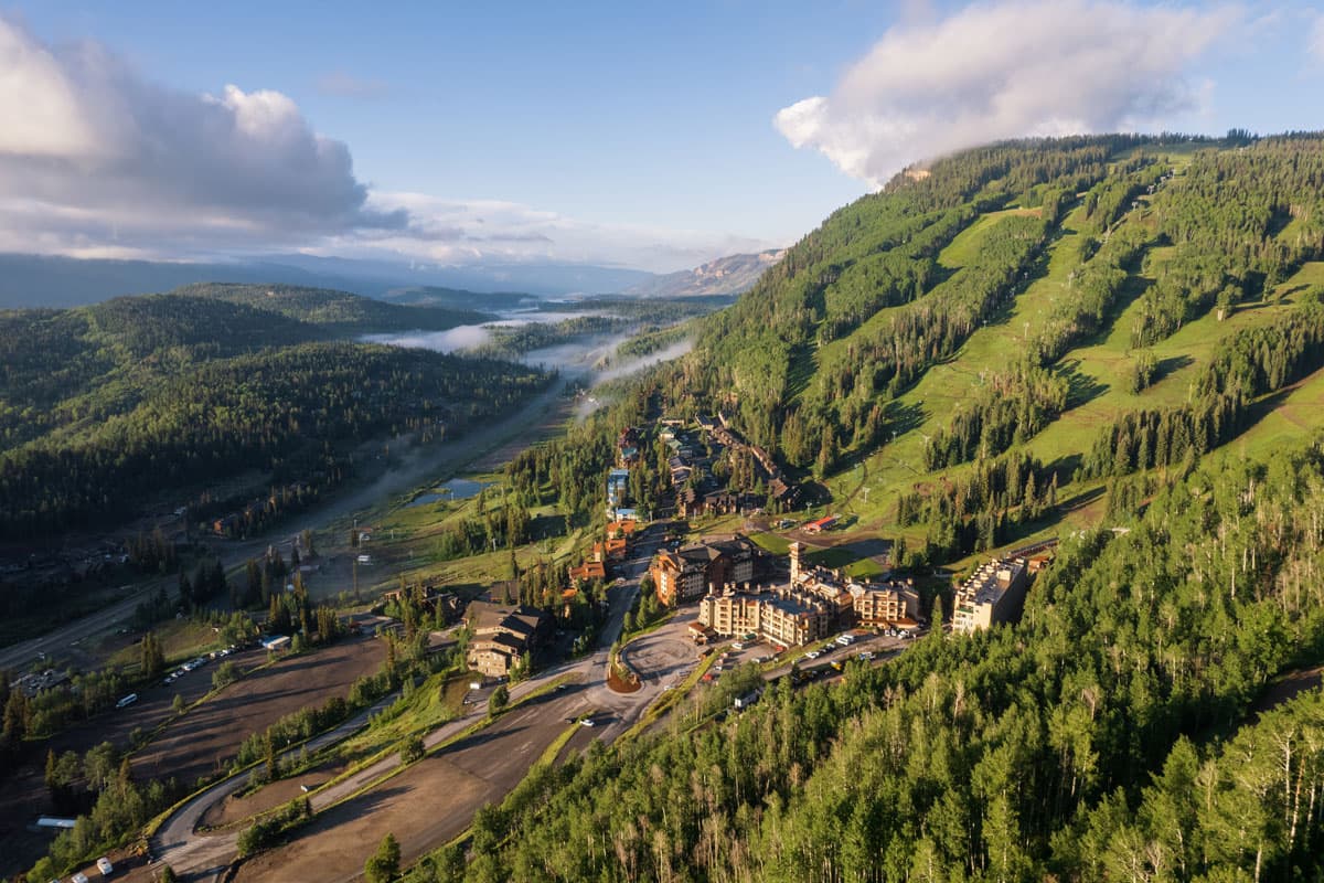 Aerial view of Purgatory Resort nestled in a lush valley, surrounded by forests in Durango.