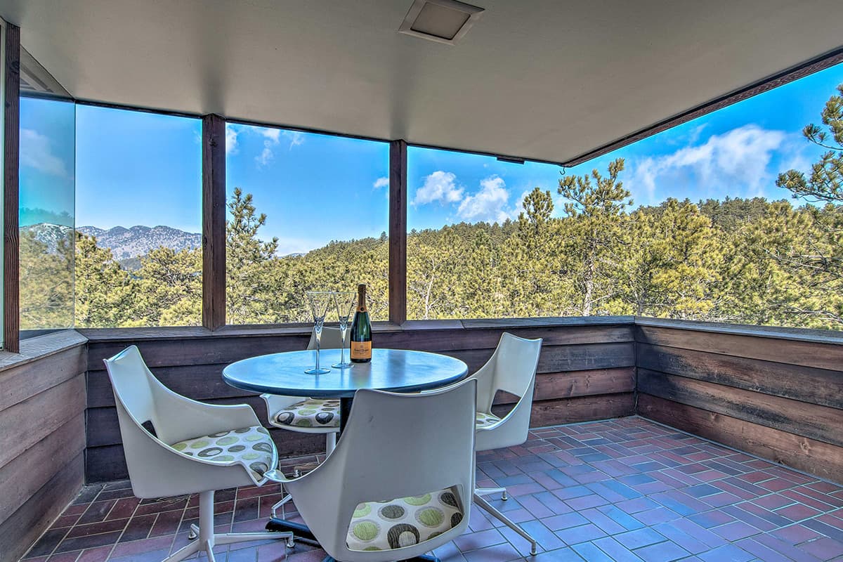 A shaded patio at Barret House offers a place to relax and take in forest and mountain views near Boulder, Colorado.