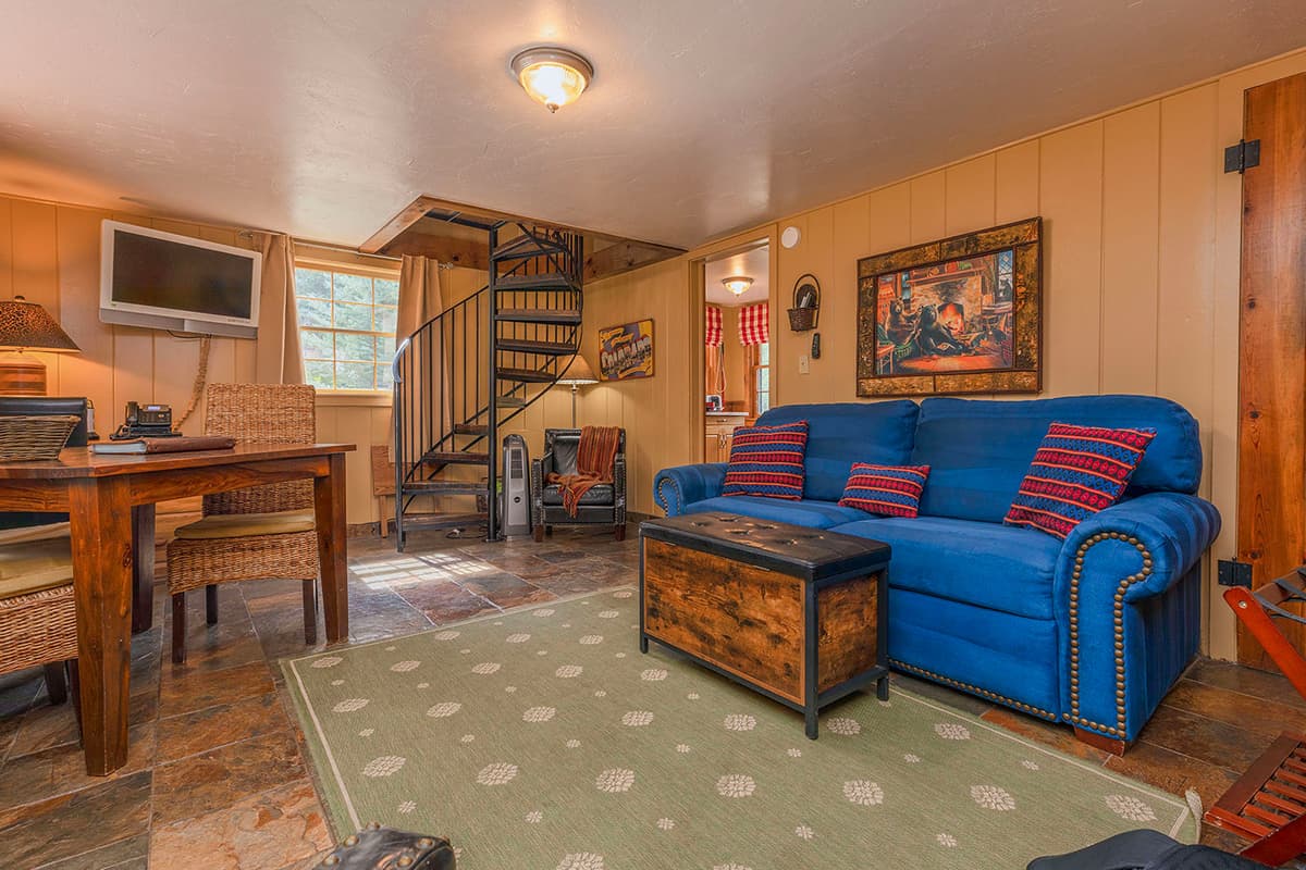 A guest cabin at O-Bar-O Cabins features wood-paneled walls, a spiral staircase and homey furnishings.