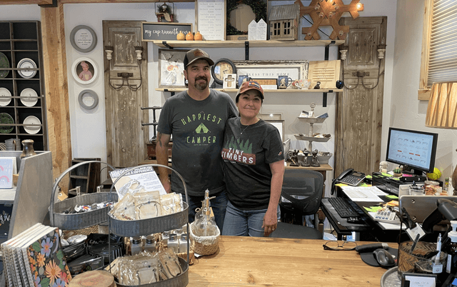 Two cafe owners standing at their cafe counter.
