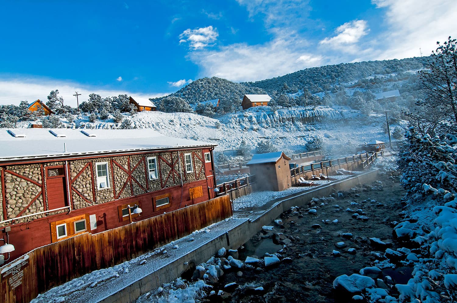 The mountain town of Nathrop, Colorado is covered in a blanket of snow. Steam from the Mt. Princeton Hot Springs Resort wafts through the cold, winter air.