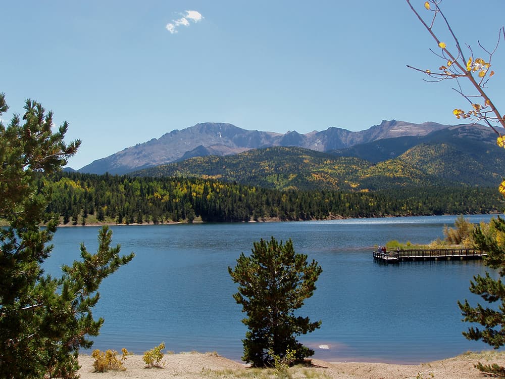 A lookout spot provides a view of blue waters and distant mountain peaks in Pike National Forest.
