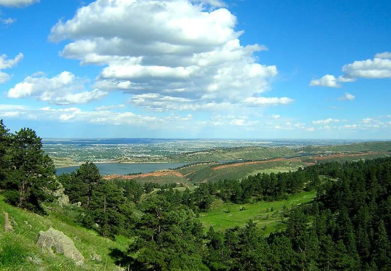 A rolling green meadow under puffy white clouds