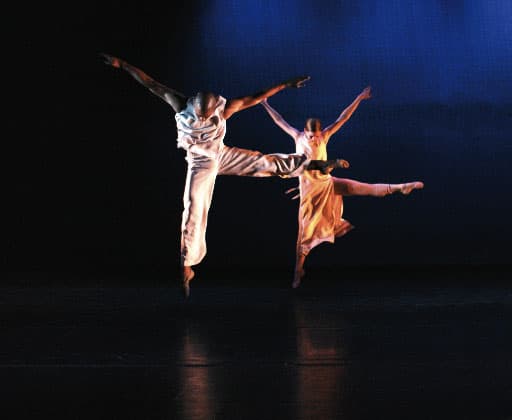 Two dancers jump in the air and pose in sync at a performing arts camp in Steamboat Springs, Colorado.