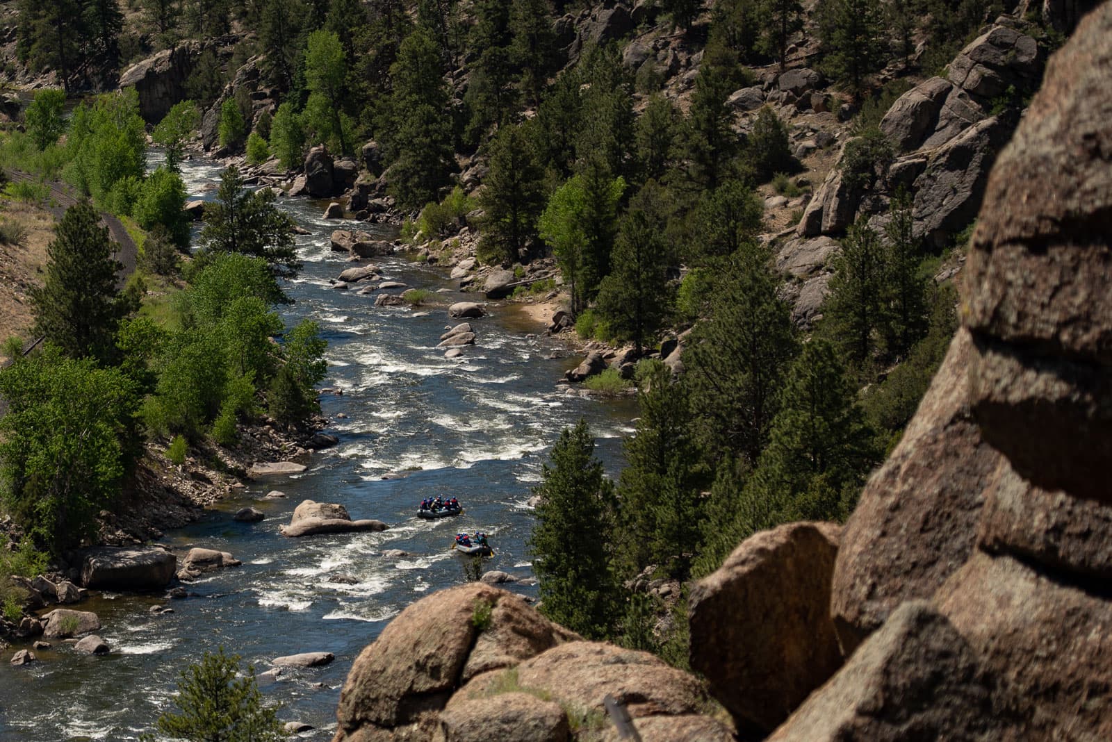 An aerial view of a group of rafts navigating the rapids