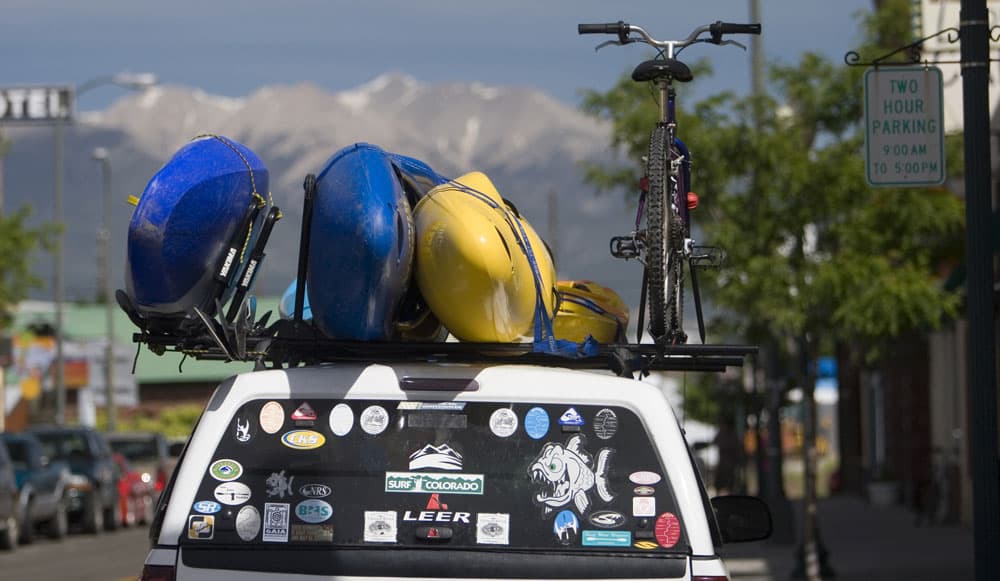 Kayaks stacked on a truck with stickers covering the back windshield