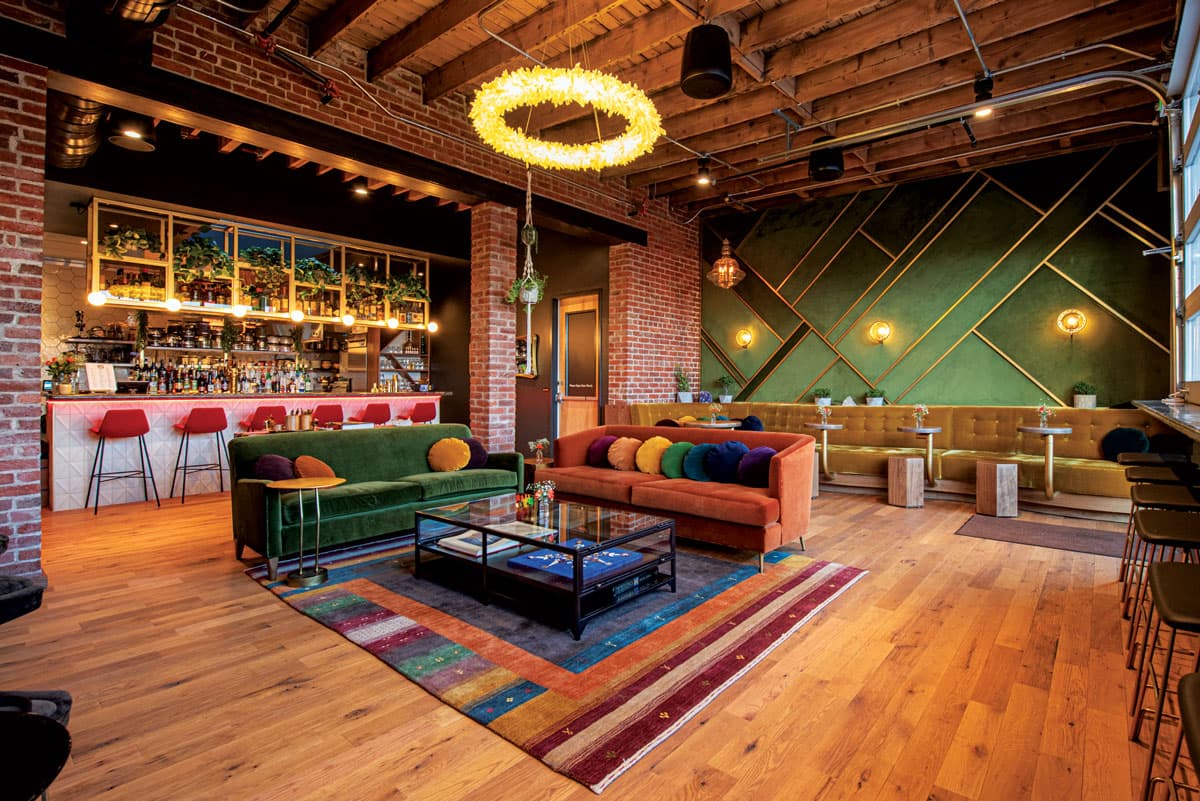 Interior of Honey Elixir Bar in Denver with funky, colorful furniture and a halo light