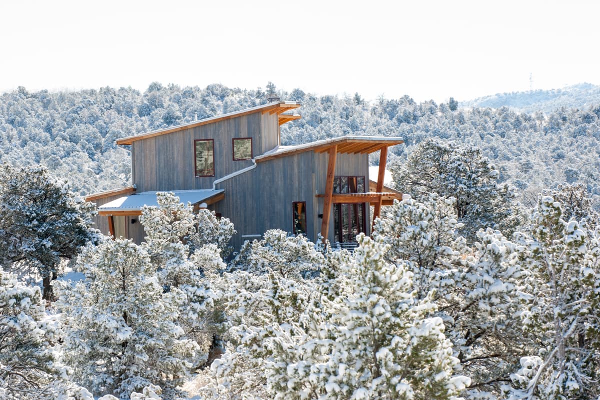 Snow covered Royal Gorge cabins rising up from trees coated in snow