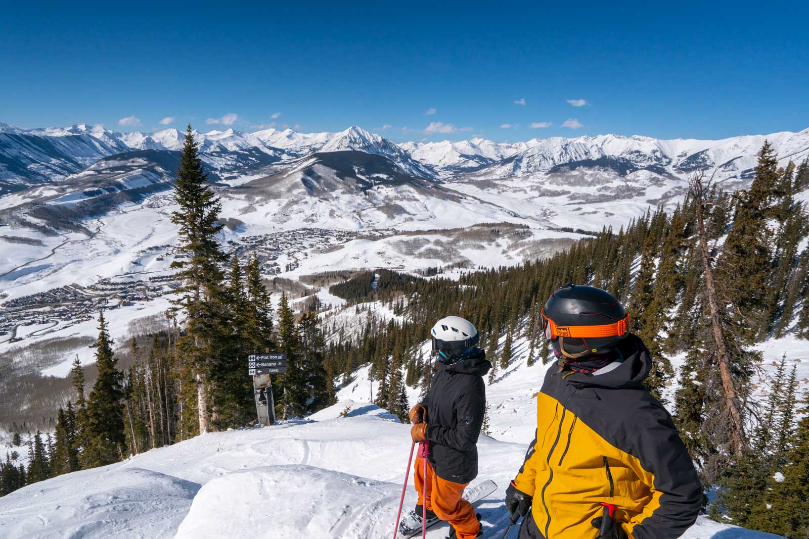Two skiers admire the view from the heart of the Rocky Mountains before dropping into a double-black ski run at Crested Butte.
