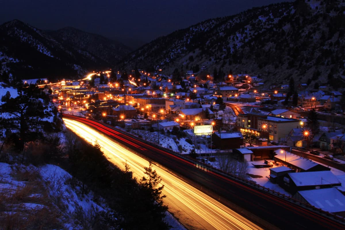 The town of Idaho Springs glows with light on a dark evening