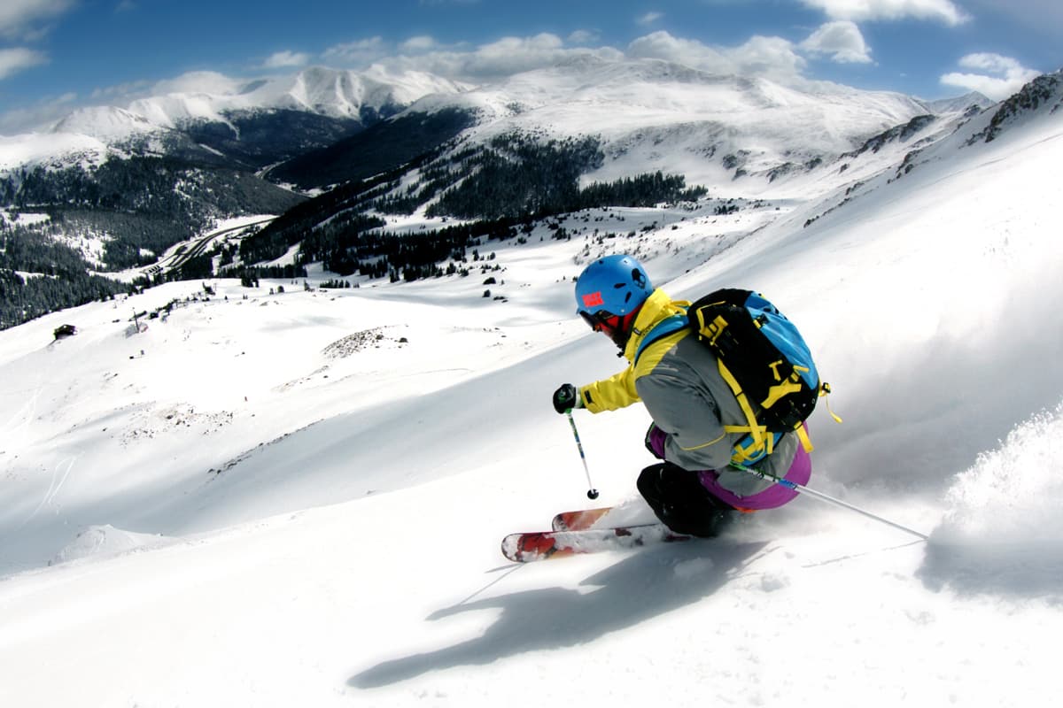 A person in ski gear carves through powder at Loveland Ski Area near Denver